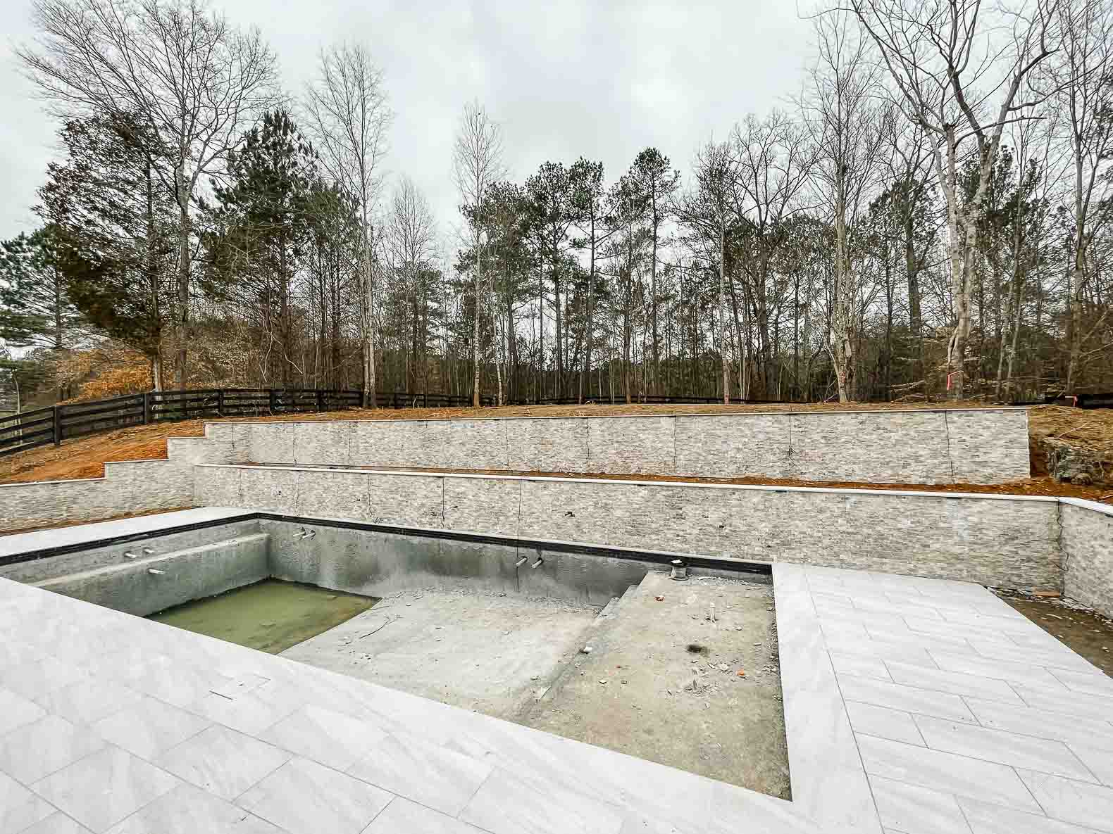 Concrete Pool Building Progress with Retaining Walls