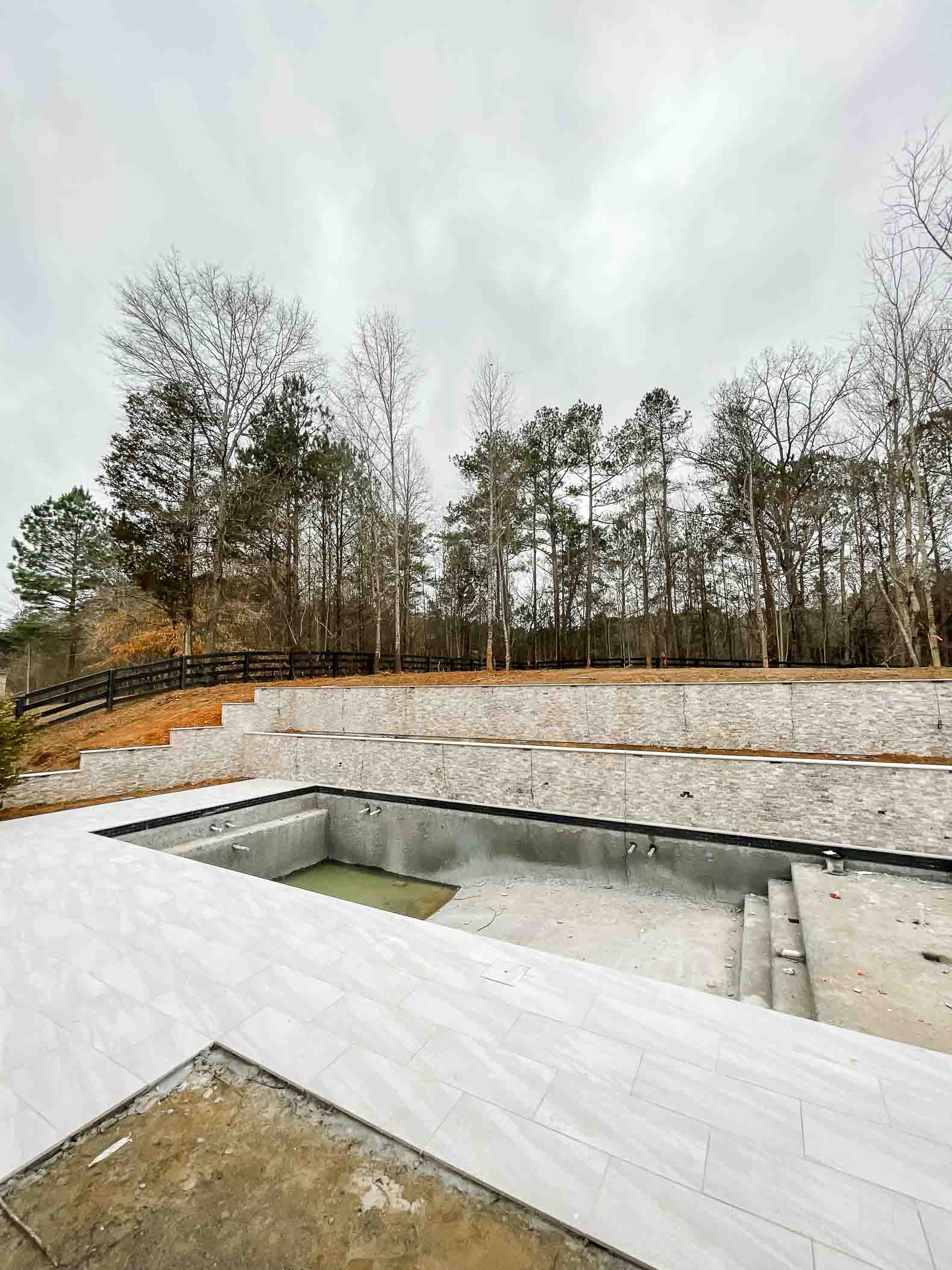 Concrete Pool Building Progress with Retaining Walls